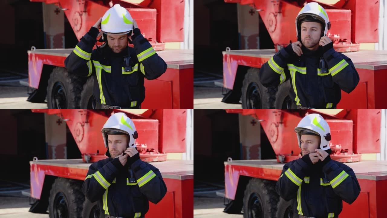 穿着装备精良的服装的英俊消防员的肖像戴上头盔，看着相机