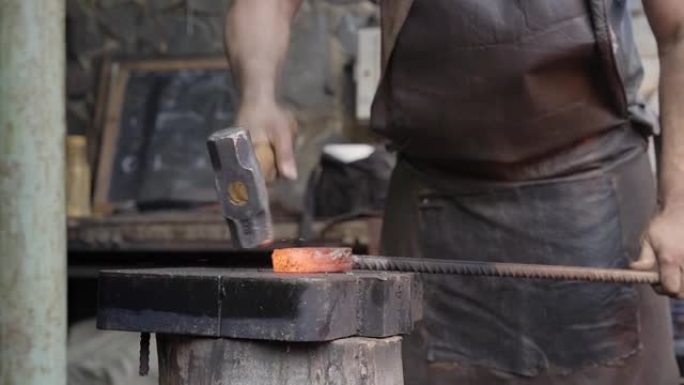 铁匠手工锻造熔融金属。击锤的特写