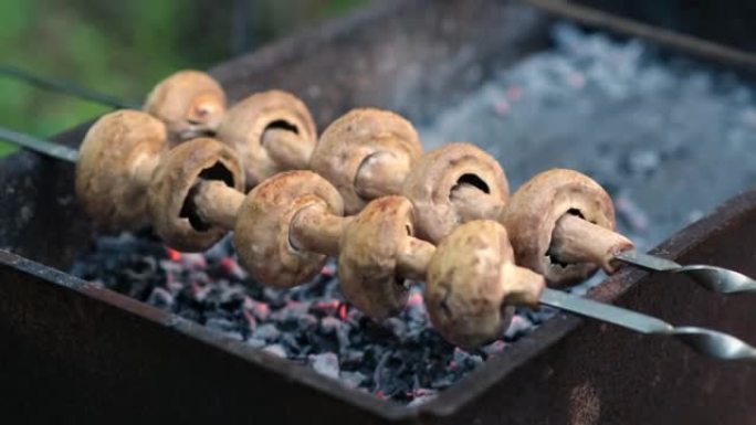 外面烤蘑菇。在烤架上烤串上烤的蘑菇