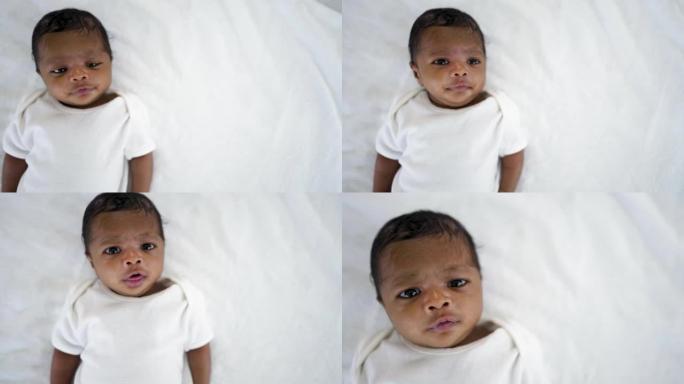 非洲快乐宝宝躺在床上的特写肖像，白色背景上有复制空间。健康的新生儿睡个午觉。家庭爱新生儿保健医疗理念