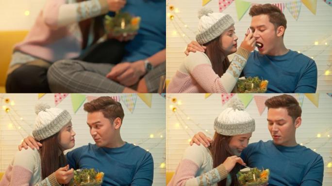年轻的亚洲夫妇一起吃饭，在家庆祝冬季节日。圣诞快乐
