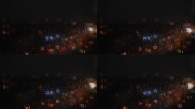 晚上雨滴从窗户上跑下来。模糊的，五彩的光闪烁。