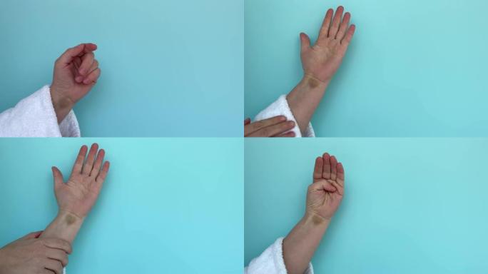 蓝色背景上有血肿的女人的手。求救信号是一种可以帮助遭受家庭暴力的人的姿态。