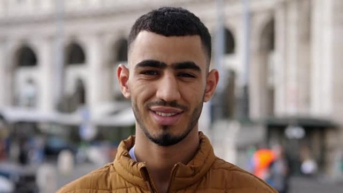 北非男子迷人的年轻人在城市对着镜头微笑