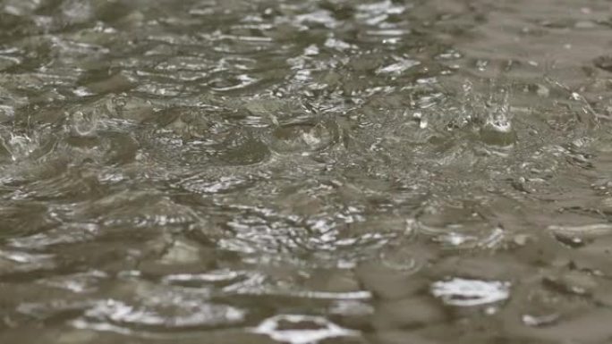 雨滴落在泥泞的水坑上