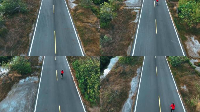 骑自行车公路旅行与女运动员骑手在早上的无人机视图