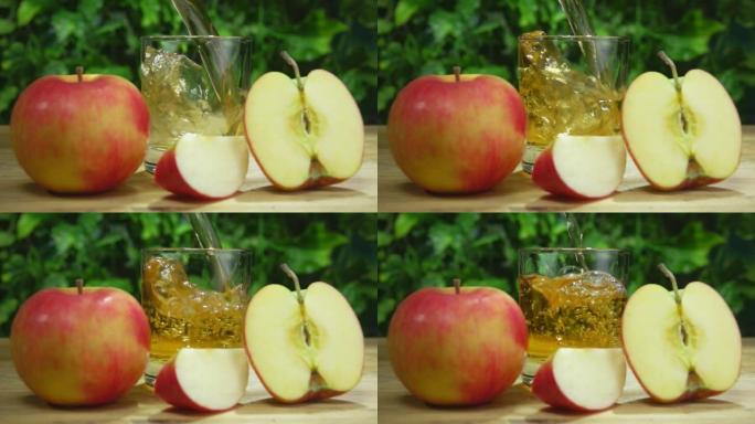 苹果汁倒在成熟大苹果旁边的小杯子里