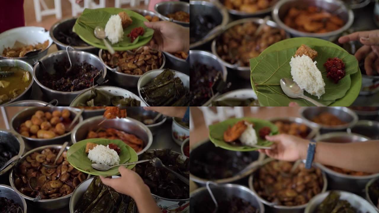 来自井里汶的典型烹饪Nasi Jamblang最喜欢的村民。服务员正在将豆豉，炸虾放在柚木叶盘上加米