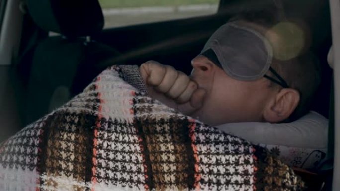 疲倦的司机戴着睡眠面罩，他的眼睛打哈欠，上床睡觉。