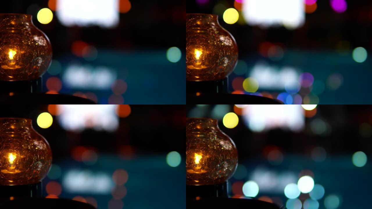 魔术灯笼。带有蜡烛的玻璃灯在泳池派对散焦图像的背景下。