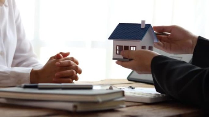 房地产经纪人解释项目中的房屋模型，以向客户详细说明，解释并介绍有关房屋和购买贷款的信息。房地产交易概