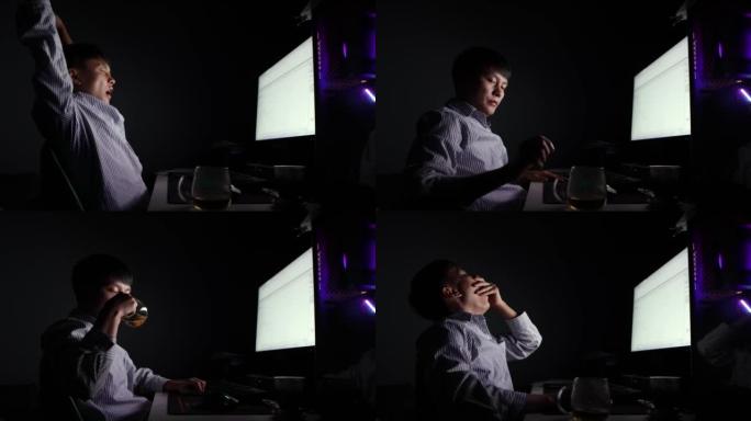 夜晚，一名亚裔男子在电脑前伸了个懒腰，打哈欠 -- 年轻人的生活方式