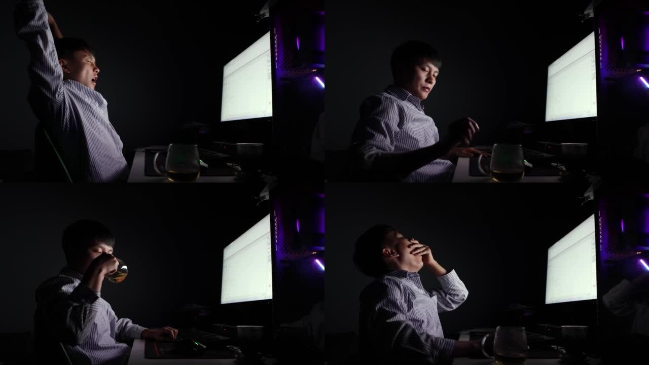 夜晚，一名亚裔男子在电脑前伸了个懒腰，打哈欠 -- 年轻人的生活方式