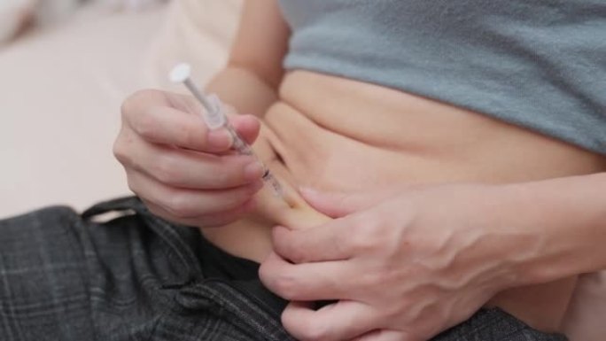 妇女通过使用注射器笔在胃或腹部注射激素以增加卵巢刺激。试管婴儿概念。人体外受精治疗妊娠注射激素