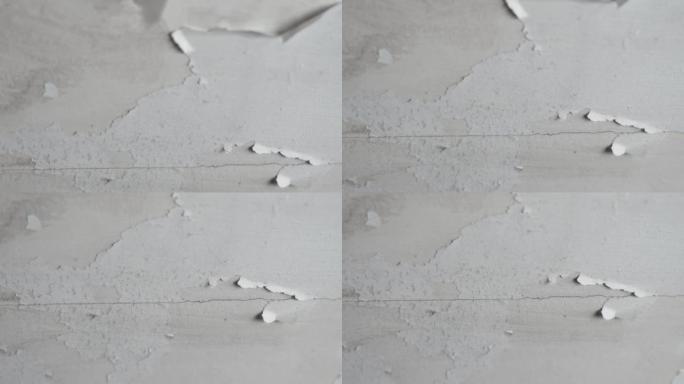 浴室天花板上白色油漆的开裂剥落层。损坏的破损干墙