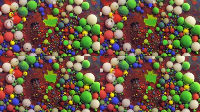 多色丙烯酸涂料气泡散布在宇宙色彩表面混合抽象设计中。金色闪闪发光的颗粒，墨球滴和混合。运动中的彩色油