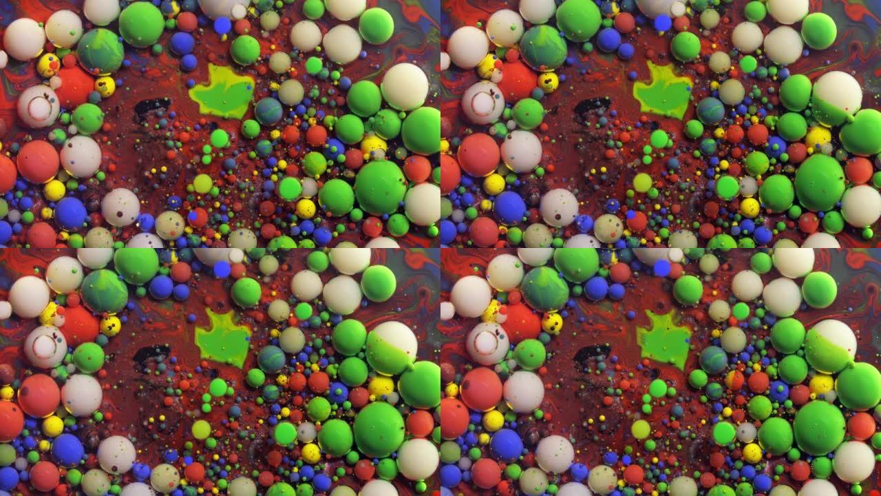 多色丙烯酸涂料气泡散布在宇宙色彩表面混合抽象设计中。金色闪闪发光的颗粒，墨球滴和混合。运动中的彩色油