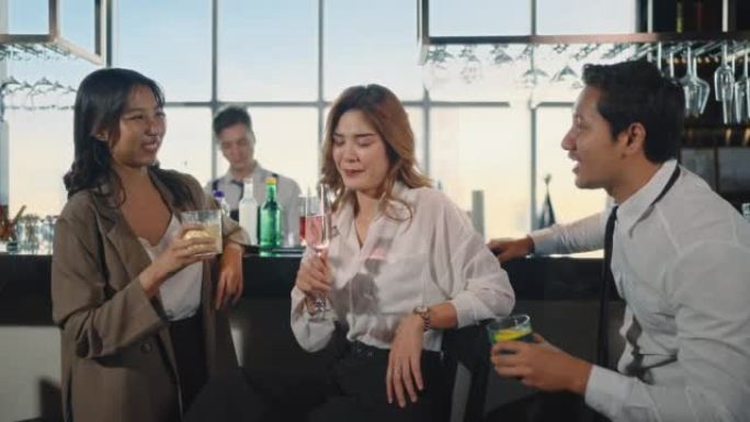 微笑的无忧无虑的朋友在餐厅的酒吧里一起喝酒