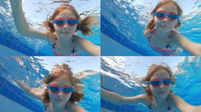 可爱的小女孩在游泳池里水下游泳