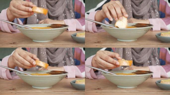 女人用手吃蒜蓉面包加汤