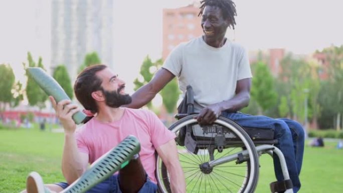 两个多种族的残疾朋友在公园里玩得开心，这位西班牙裔男子的慢动作展示了他的假肢，多样性的人们城市生活方