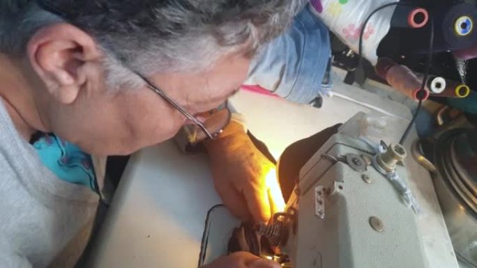 成年女裁缝的肖像在缝纫机上工作，工作库存视频