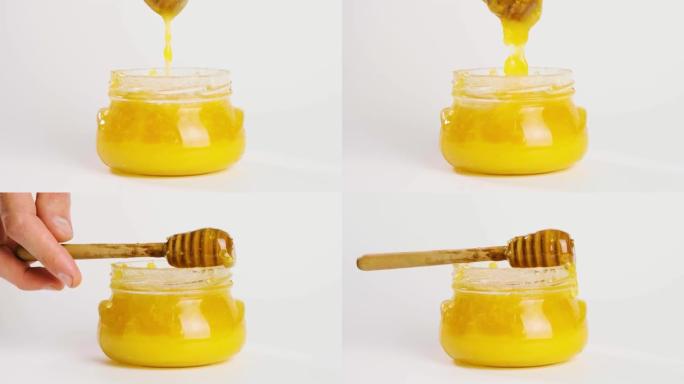 蜂蜜用蜂蜡从蜂蜜勺子里滴在白色背景的罐子里。天然液体蜂蜜从滴头流下来。