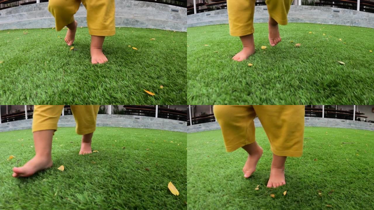 穿着黄色短裤在绿色草地上奔跑的儿童腿的特写镜头。在夏季，为了提高健康和免疫力，赤脚在地面上跑步很有用