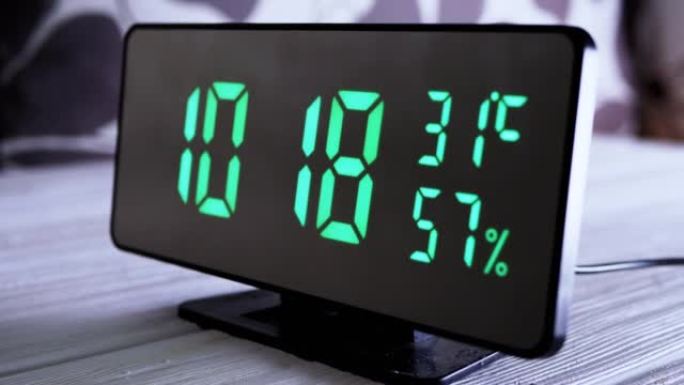 数字时钟在绿色显示上午10:18上显示时间、温度、空气湿度