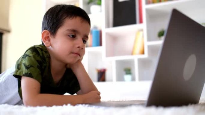 Little boy watching on laptop screen