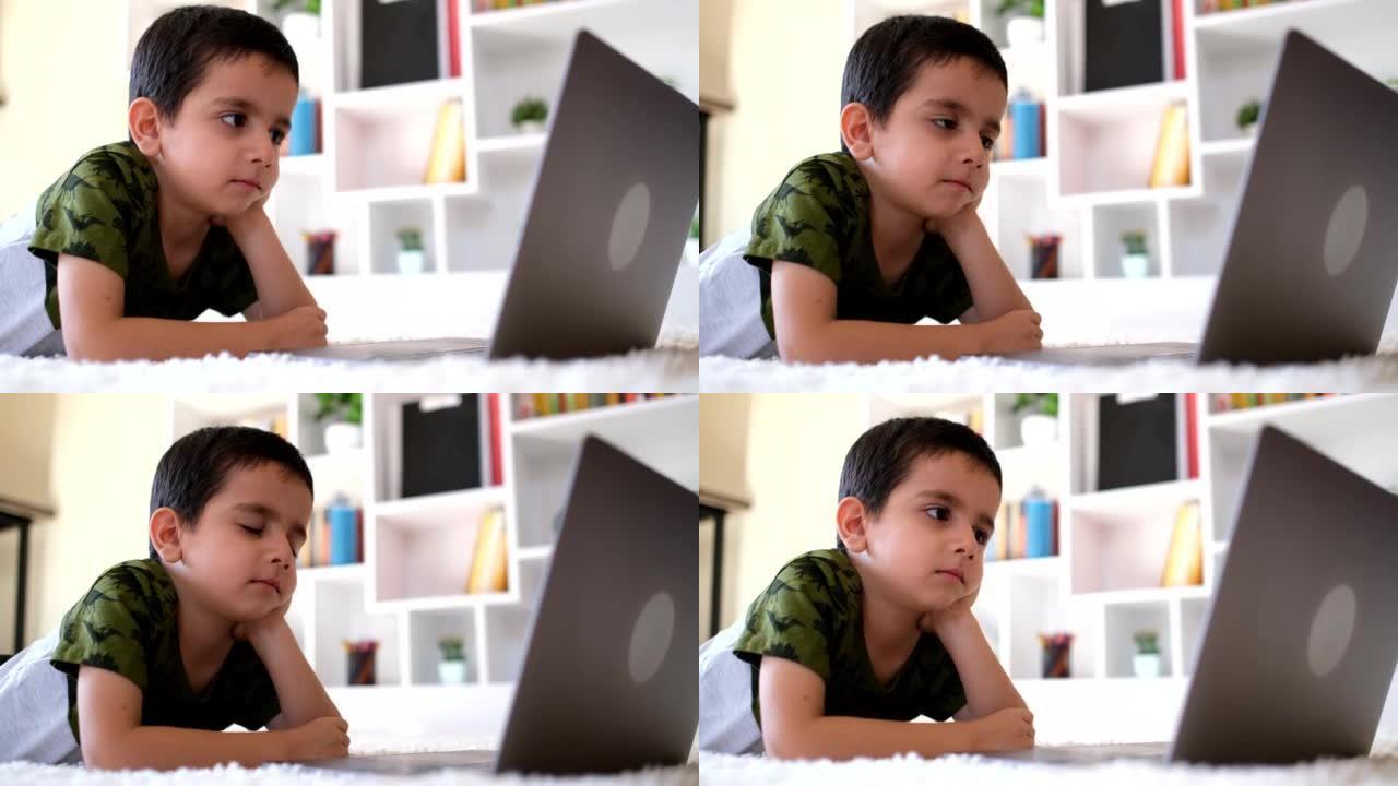 Little boy watching on laptop screen