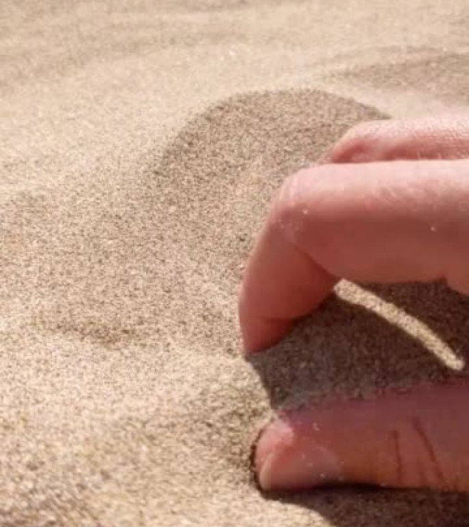 女孩的手在沙子中移动的慢动作镜头