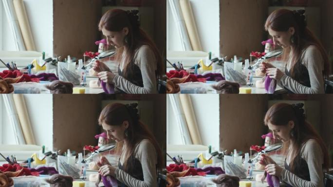 年轻女子用毡针制造玩具刺伤羊毛