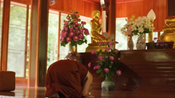 佛教僧侣在寺庙的佛像前鞠躬