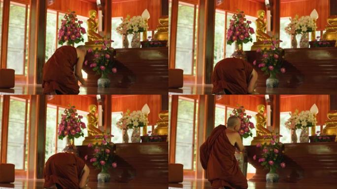佛教僧侣在寺庙的佛像前鞠躬
