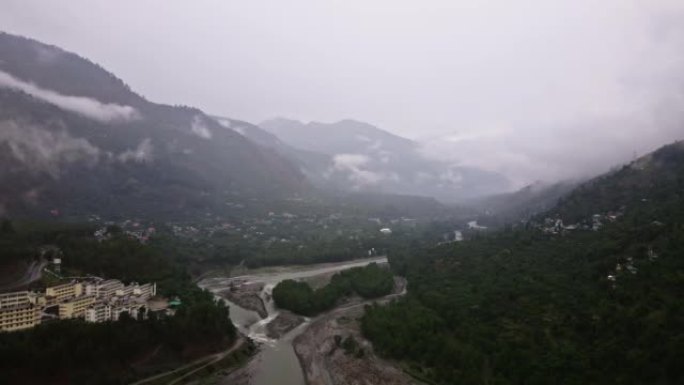 Bias river in between towns of Himalayas, clouds a