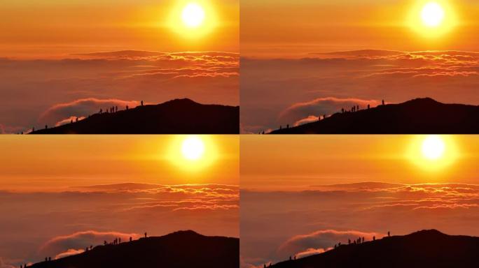 戏剧性的日落期间游客在山顶上的鸟瞰图