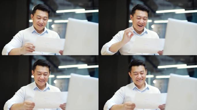 肖像快乐的亚洲男人商业男人雇员阅读文件报告文件项目信息信件银行融资通知喜悦感到幸福庆祝胜利