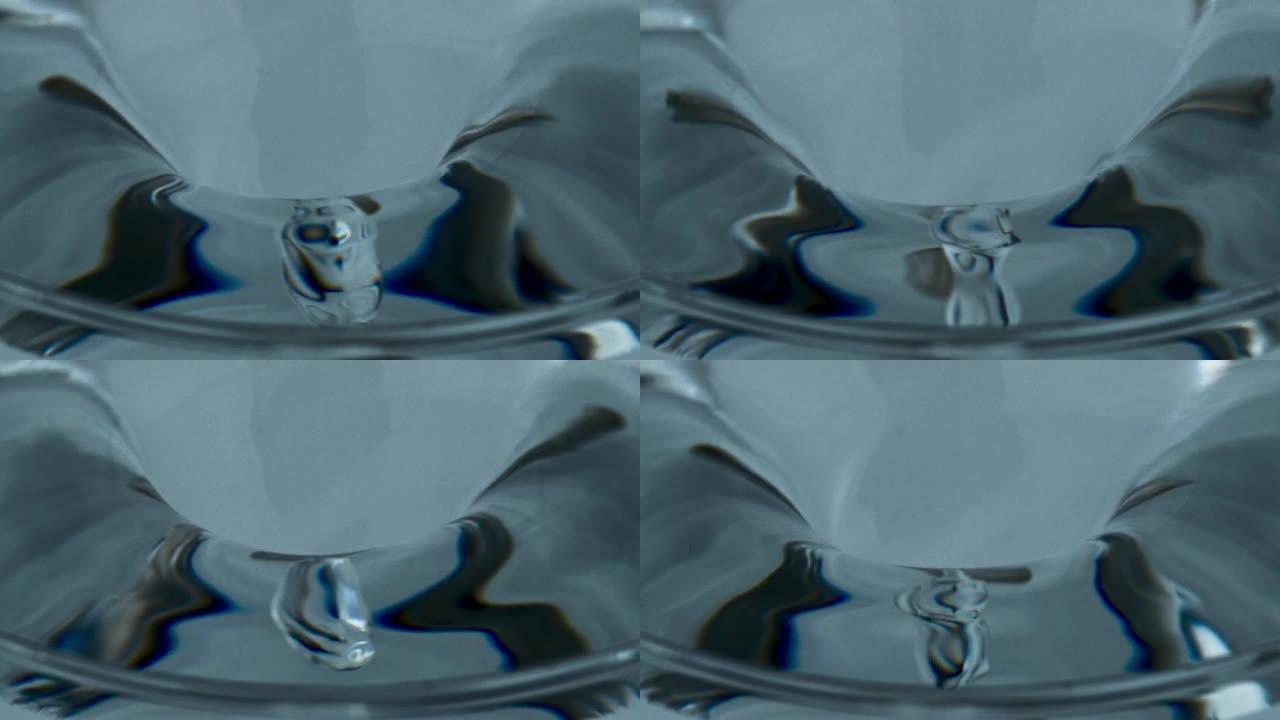 冰鸡尾酒在玻璃器皿内制造漏斗。容器中的透明水涡流