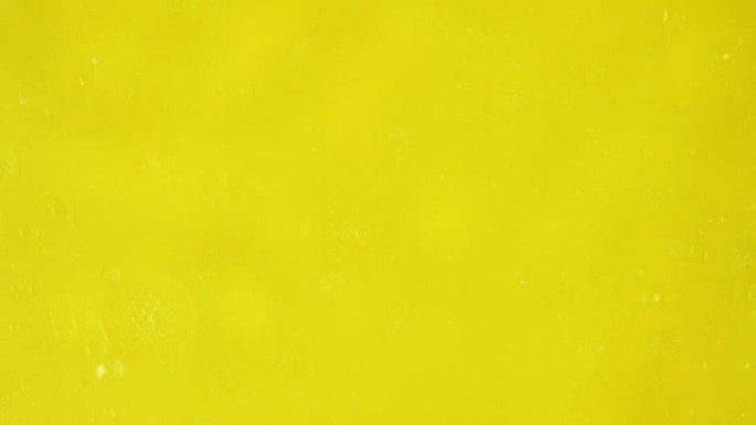 大的透明气泡沿着较小的气泡滑动，在黄色背景上移动它们。拍摄用于广告的贴剂成分