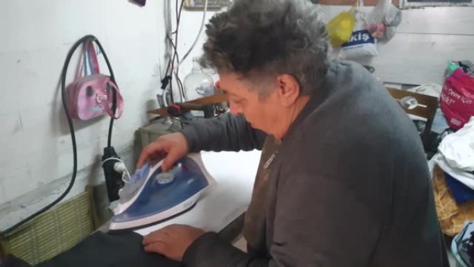 成年女裁缝在缝纫机上工作的肖像