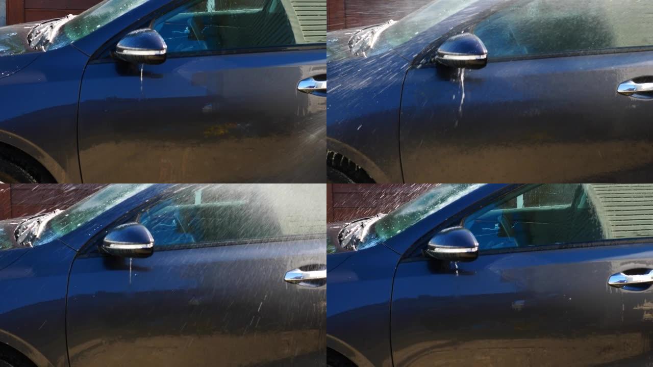 用水从外部的软管手动洗车车身护理，汽车的售前准备。洗车机用水冲洗身体中的肥皂溶液