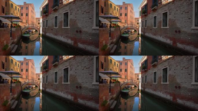 意大利威尼斯一条运河上的吊船，有老房子，靠近圣马可和里亚托桥的大教堂教堂。标志性的威尼斯夏季嘉年华旅