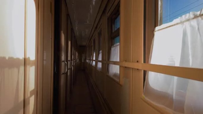 火车的走廊在明亮的阳光下穿过窗户。旅程概念