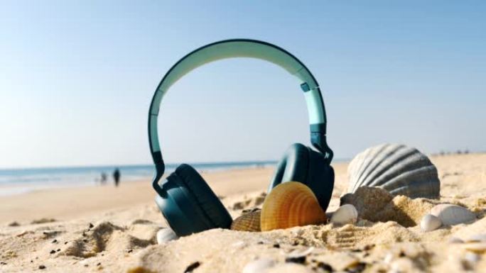 夏日 -- 海滩上的耳机 -- 度假、旅行、放松概念