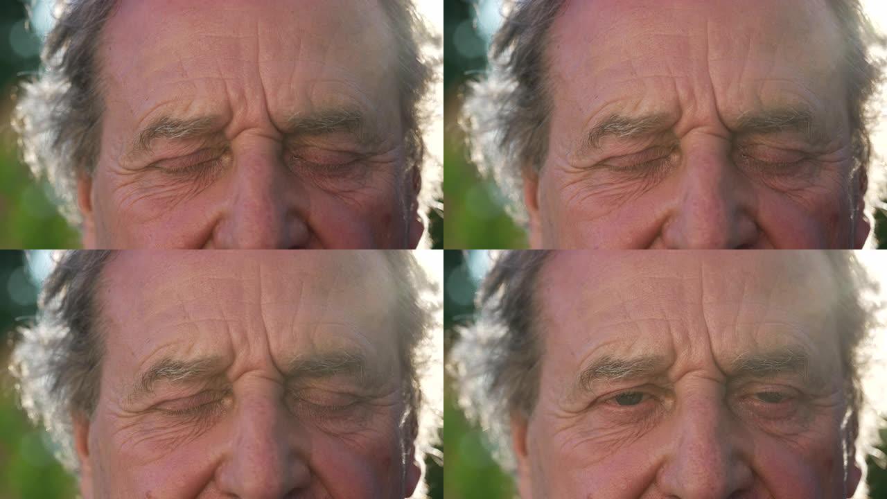 一位资深男子在大自然中向外面的相机睁开眼睛。一个成熟的老年男性从冥想中醒来