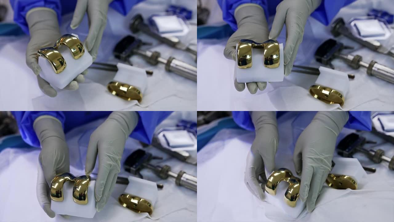 医生手中的膝关节假体的闪亮金属部件。医生展示膝盖手术的材料。特写。