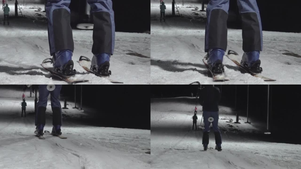 模糊的焦点背景。晚上在滑雪胜地山上穿着蓝色运动服的滑雪升降机的男子