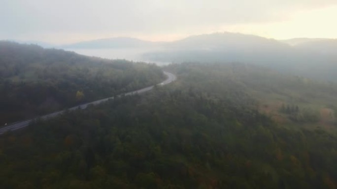 无人机空中秋晨山路，孤车笼罩在浓雾中