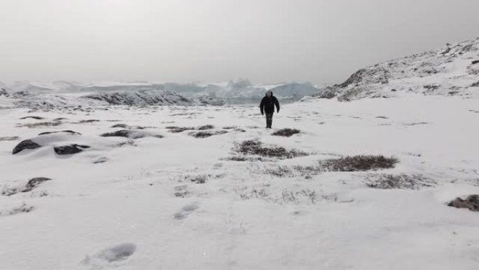 沿着雪地上的脚印拍摄的人的极宽镜头